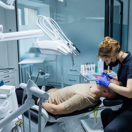 Modern stomatological office. An orthodontist installs braces. Treatment of teeth of a person with an incorrect bite. Treatment of teeth